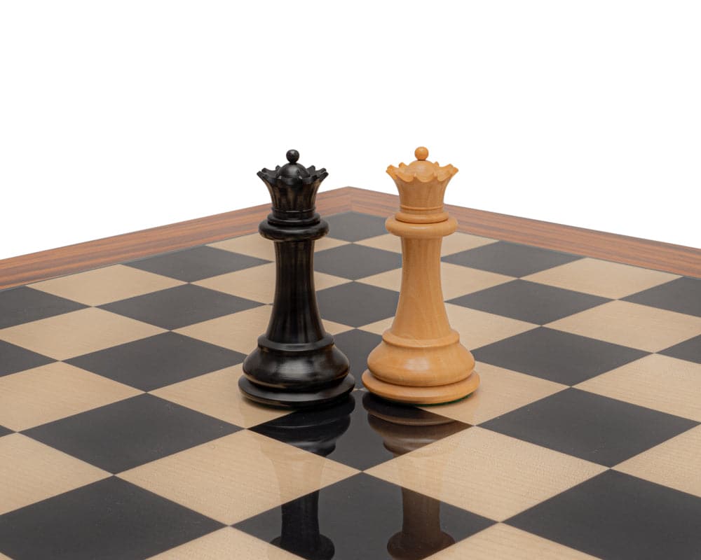 Ebony and boxwood Staunton chess kings on a chessboard.